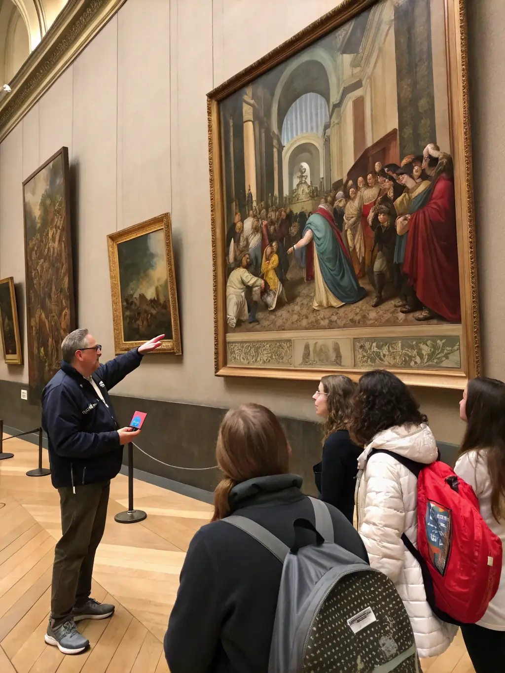 A photograph of a guided tour in Musée de Prat, with a guide explaining the history of an artifact to a group of attentive visitors.