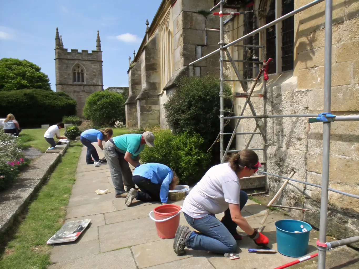 A photograph of volunteers working on a heritage preservation project in Labrousse, restoring a historical building or landmark to preserve it for future generations.